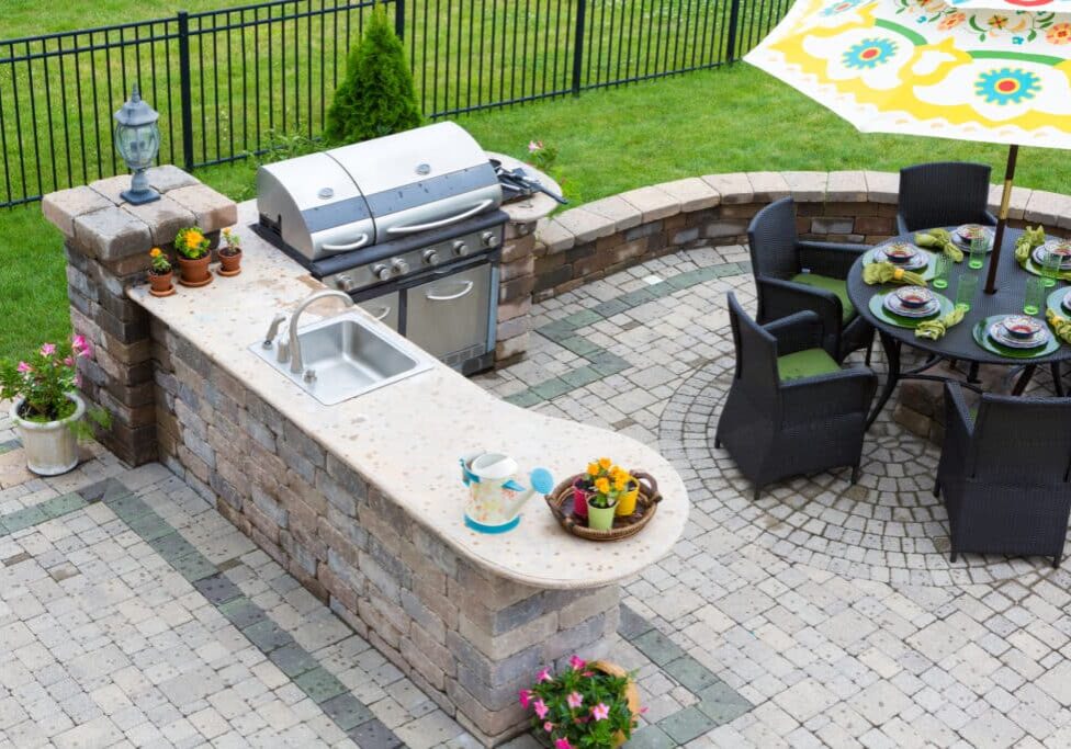 Outdoor kitchen and dining table on a paved patio