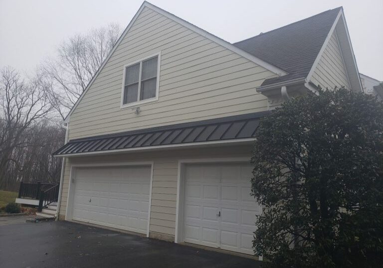 completed stucco remediation, with James Hardie fiber cement lap siding and new garage entrance roof with standing seam roofing